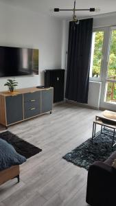 a living room with a flat screen tv on the wall at City Break Apartment Koszalin centrum in Koszalin