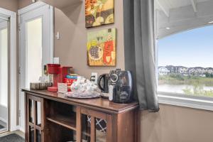 uma mesa com uma máquina de café ao lado de uma janela em 52-3 Bed Suite On Lake Central Ac By Airport em Calgary
