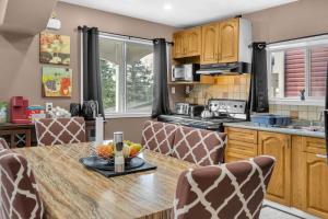a kitchen with a table with a bowl of fruit on it at 52-3 Bed Suite On Lake Central Ac By Airport in Calgary