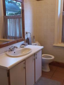 a bathroom with a sink and a toilet and a mirror at The Terraces in Kroonstad