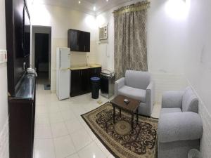 راسيات الحمدانية - Hotel Rasiyat في جدة: غرفة معيشة مع أريكة وطاولة