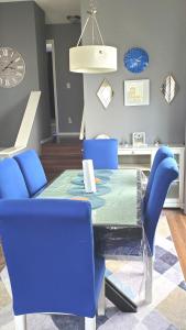 uma sala de jantar com uma mesa azul e cadeiras azuis em 12 Spacious Home W Ac, Crib, Garage, By Airport em Calgary