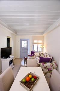una sala de estar con una mesa con un bol de fruta. en Aegean Diamonds Boutique Villas en Loutraki
