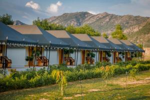 um edifício com um telhado com montanhas ao fundo em Teerth Camp Pushkar em Pushkar