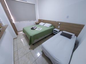 Habitación pequeña con 2 camas y ventana en Studio 516 Copacabana Av Atlântica, Posto 6, en Río de Janeiro