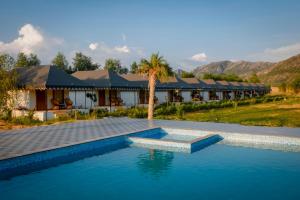 um resort com uma piscina em frente a um edifício em Teerth Camp Pushkar em Pushkar