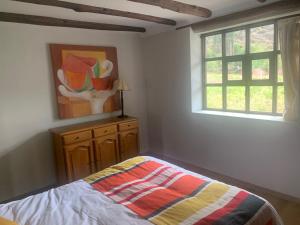 een slaapkamer met een bed en een schilderij aan de muur bij Habitacion en Casa de Campo, Valle Sagrado de los Incas in La Planicie