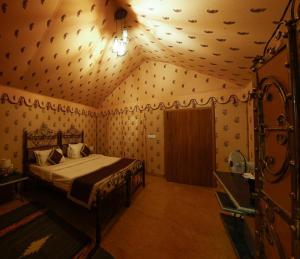 ein Schlafzimmer mit einem Bett in einem Zimmer mit Tapete in der Unterkunft Teerth Camp Pushkar in Pushkar