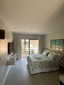 a bedroom with a large bed and a television at Apartamento no Condominio Amaré in Barra Grande
