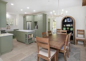 a kitchen with green cabinets and a wooden table at Kensington in Edwards