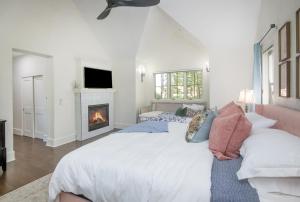 a white bedroom with a bed and a fireplace at Kensington in Edwards