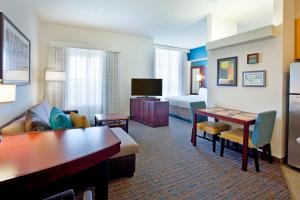 a hotel room with a couch and a table at Residence Inn Baltimore Hunt Valley in Hunt Valley