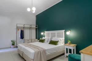 a bedroom with a large bed and a green wall at Centro Y Mar! Central Penthouse with Terrace! in Argostoli