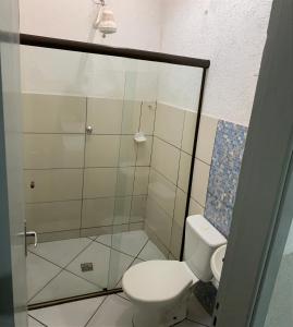 a bathroom with a toilet and a glass shower at Hotel GranDourados in Dourados