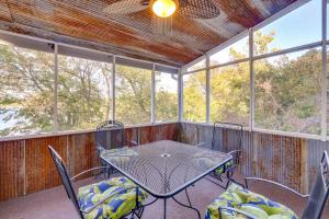 eine abgeschirmte Veranda mit einem Tisch und Stühlen in der Unterkunft Lakefront Gem with Screened Porch and Game Room! in Shell Knob