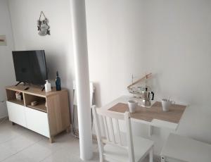 um quarto branco com uma mesa e uma televisão num armário em Mirador de Sotavento apartment 103 em Costa Calma