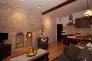 a living room with a stone wall with a fireplace at Old Town Apartments in Korčula