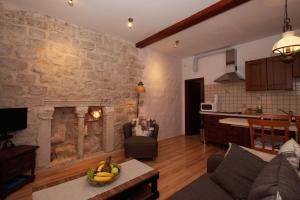 a living room with a stone wall with a fireplace at Sunny Town in Korčula