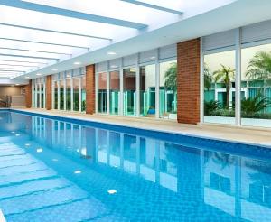 a swimming pool in a hotel with windows and a building at Acolhedor Studio no Batel/Água Verde em frente ao Shopping Curitiba in Curitiba