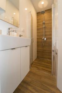 uma casa de banho com um chuveiro e uma bancada branca em Old Town Apartments em Korčula