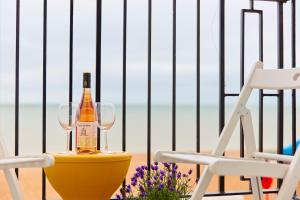 eine Flasche Champagner und zwei Gläser auf einem Tisch am Strand in der Unterkunft Spacious beach front apartment with stunning sea views in Deal