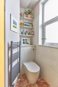 a bathroom with a toilet and a window at Spacious beach front apartment with stunning sea views in Deal