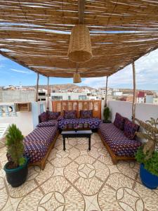 a patio with couches and a table on a roof at Atlas Surf Morocco in Tamraght Ouzdar
