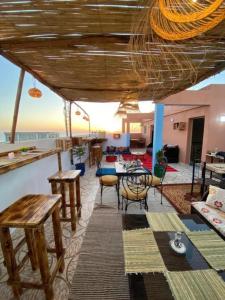 a living room with a table and chairs at Atlas Surf Morocco in Tamraght Ouzdar