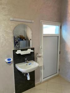 a bathroom with a sink and a mirror at Atlas Surf Morocco in Tamraght Ouzdar