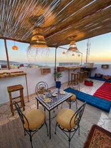 a living room with a table and chairs and a view at Atlas Surf Morocco in Tamraght Ouzdar