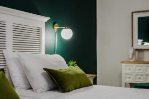 a bedroom with a white bed with a green wall at Centro Y Mar! Central Penthouse with Terrace! in Argostoli