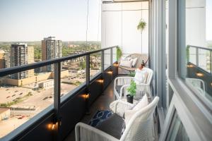a balcony with white chairs and a view of a city at The Union B24 in Kitchener