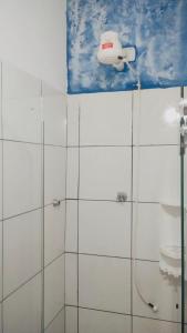 a bathroom with a shower with a camera on the wall at Morro Hostel e Pousada in Morro de São Paulo