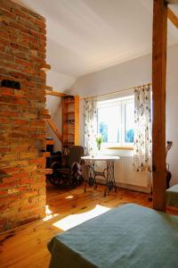 um quarto com uma parede de tijolos, uma mesa e uma janela em Agroturystyka TWÓJ KĄCIK em Kurzetnik