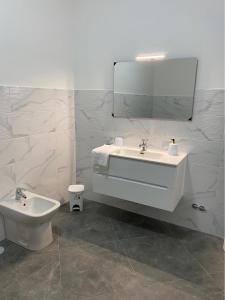 Un baño con lavabo, inodoro y espejo. en Suite Home, en Nápoles