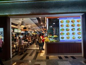 Times Square Service Suites Kuala Lumpur في كوالالمبور: زحمة الناس تاكل في المطعم
