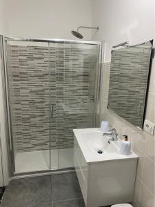 Un baño con lavabo y ducha con puerta de cristal. en Suite Home, en Nápoles 31 fotos más