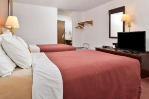 a hotel room with two beds and a flat screen tv at America's Best Value Inn Beardstown in Beardstown