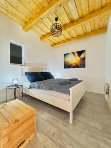 a bedroom with a bed and a flat screen tv at Casa Mido Badacsony in Badacsonytomaj