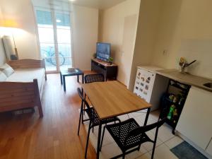 eine Küche und ein Wohnzimmer mit einem Tisch und Stühlen in der Unterkunft Versailles Trip Appartement in Buc