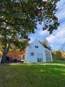 a white barn with a clock on the side of it at Casa Mido Badacsony in Badacsonytomaj +55 photos