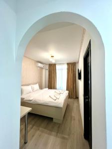 a hotel room with a bed and an archway at Hotel Marina 2 in Bucharest