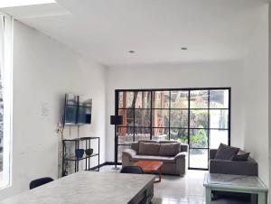 uma sala de estar branca com um sofá e uma mesa em Vila Batu Bale-Bale em Batu