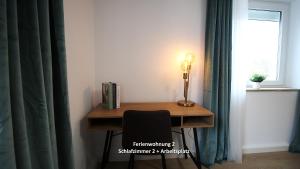 a desk with a lamp and a chair next to a window at 3 Zimmerwohnung in Würzburg nähe Uniklinik, free parking in Würzburg