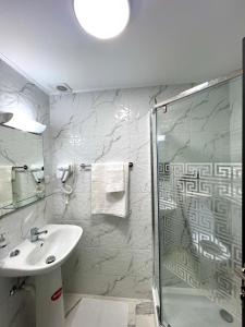 a bathroom with a sink and a shower at Hotel Marina 2 in Bucharest