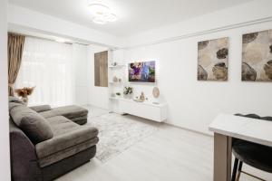 een witte woonkamer met een bank en een stoel bij Pandora's Apartments in Suceava