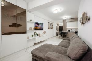 a living room with a couch and a kitchen at Pandora's Apartments in Suceava