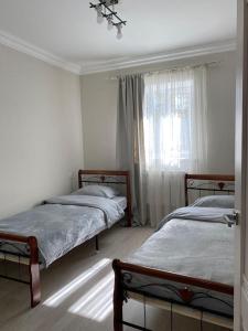 1 dormitorio con 2 camas y ventana en Lidiani Guest House en Gyumri