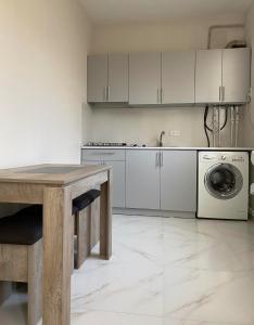 a kitchen with a table and a washing machine at Lidiani Guest House in Gyumri