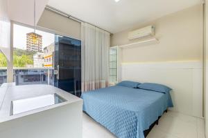 um quarto com uma cama e uma grande janela em Casa com Jacuzzi ideal para Férias de Famílias - 3 dorms 6 pessoas em Bombinhas